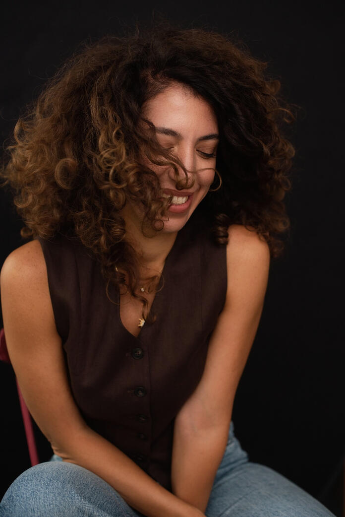 Photo of curly woman, dark background, Berlin studio photoshoot Photo of curly woman, dark background, Berlin studio photoshoot